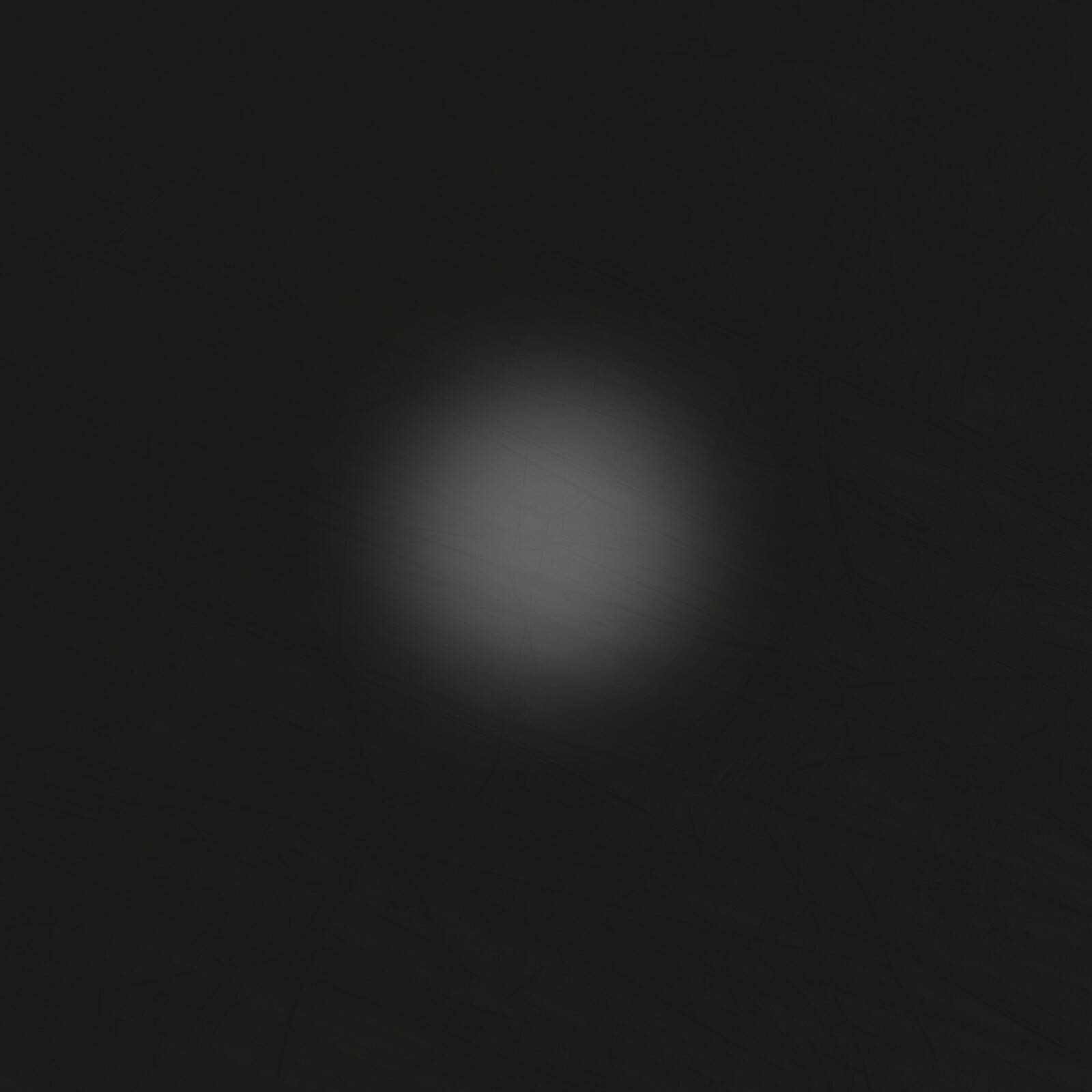 A blurred gray circle on a dark background.